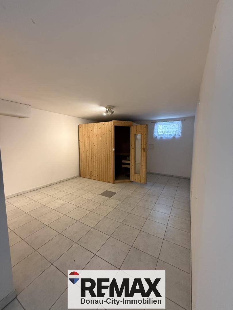 Raum im Untergeschoss mit einer eingebauten Sauna und Fliesenboden, ideal für Wellness.