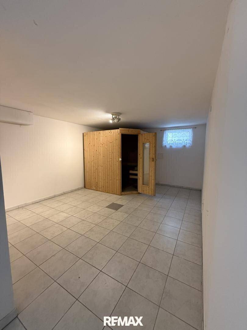Geräumiger Kellerraum mit Fliesenboden und einer eingebauten Sauna für Wellnessmomente.