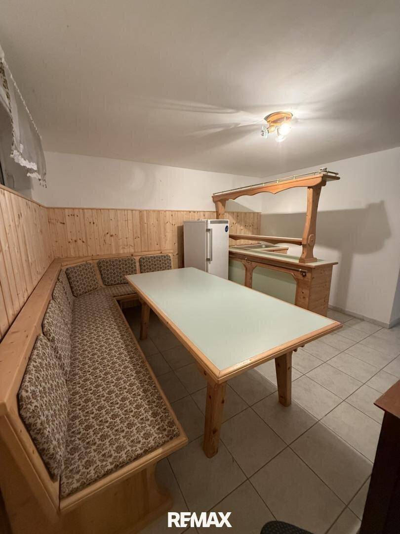 Gemütlicher Kellerraum mit Holzvertäfelung, Sitzecke und Barbereich für gesellige Abende.