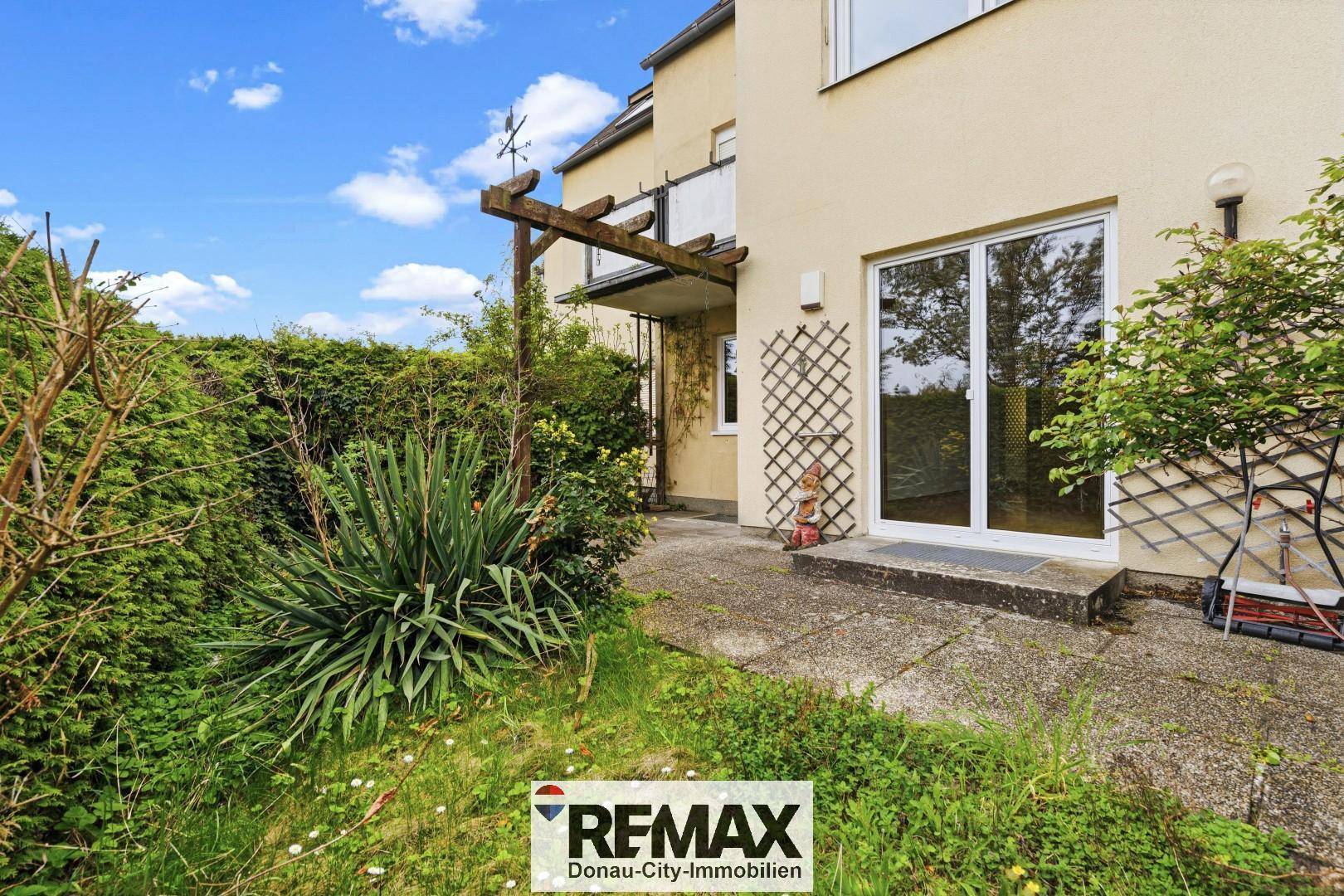 Kleiner Gartenbereich mit Terrasse und üppiger Bepflanzung, ideal zum Entspannen im Freien.