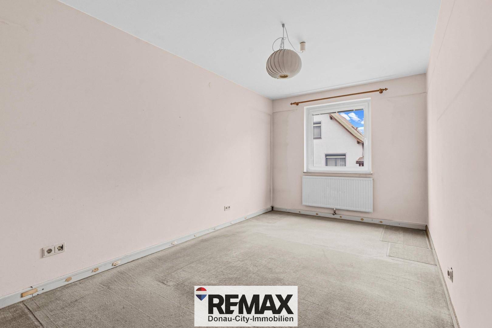 Helles Schlafzimmer mit Fenster und Heizkörper, bereit für individuelle Gestaltung.