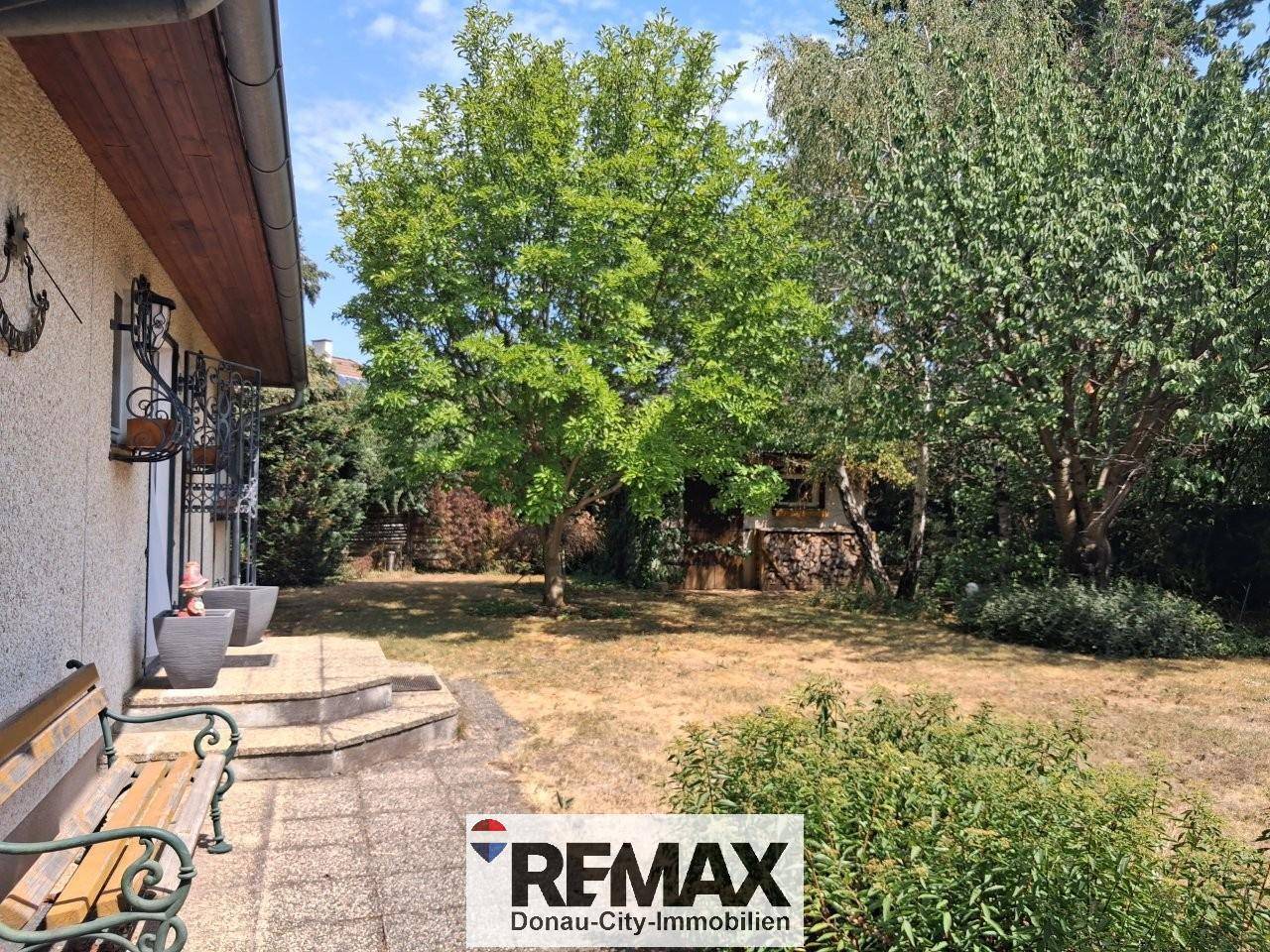 Weitläufiger Gartenbereich mit Rasenfläche und altem Baumbestand.