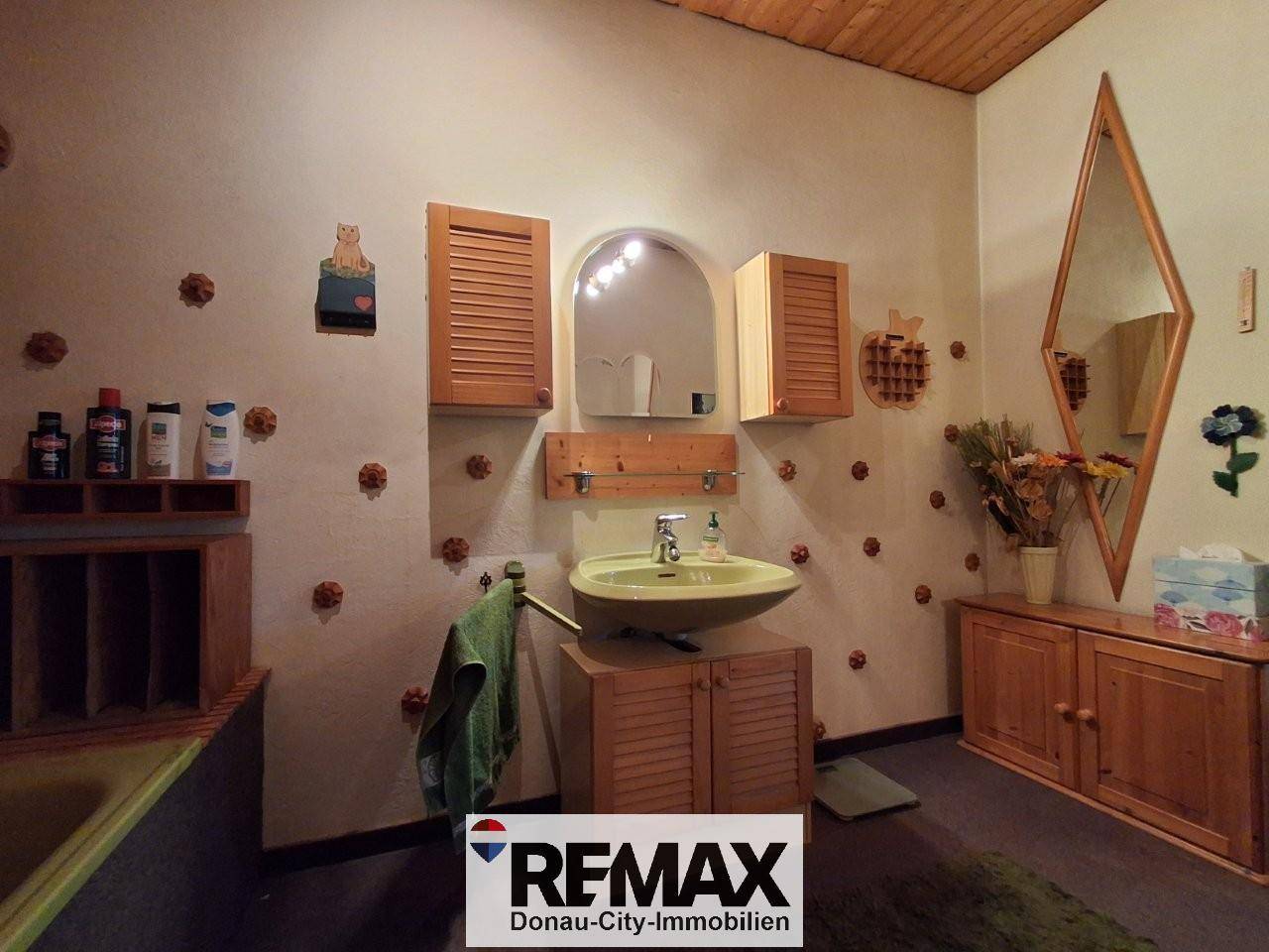 Traditionelles Badezimmer mit Einzelwaschbecken, Holzmöbeln und dekorativen Elementen.