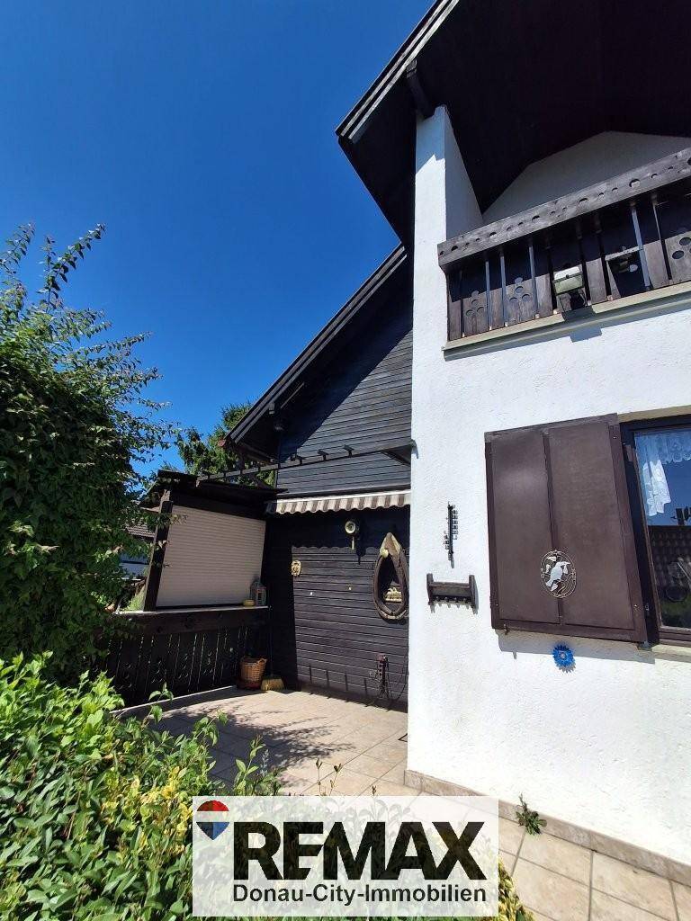 Seitenansicht des Hauses mit Terrasse und Zugang zum Gartenbereich.