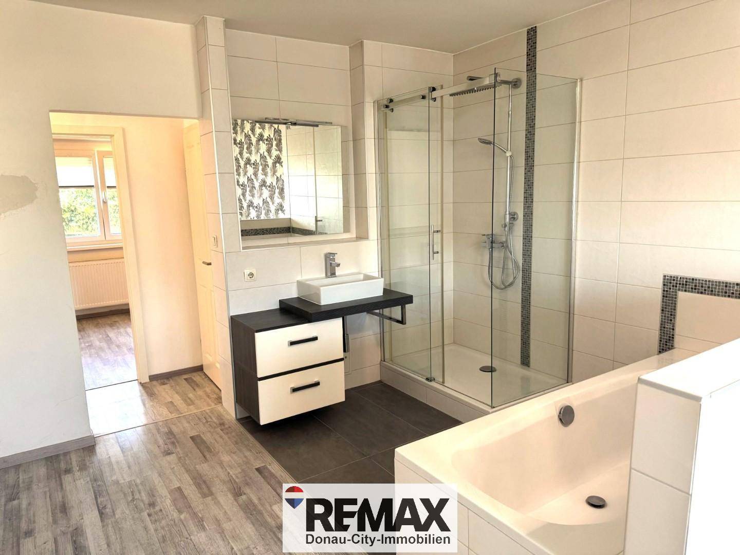 Modernes Badezimmer mit Dusche, Badewanne und Einzelwaschbecken.