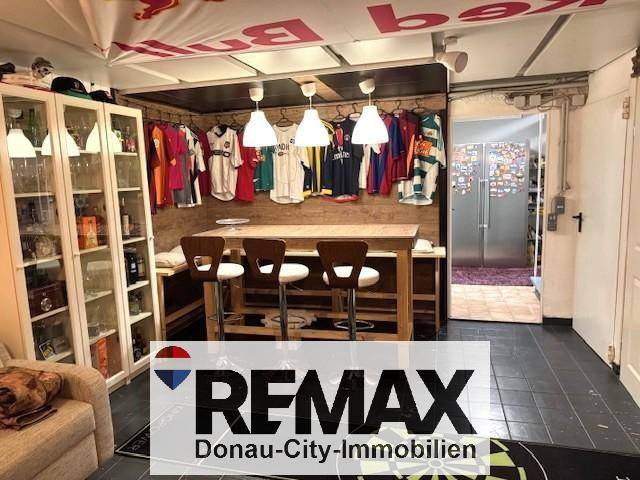 Ausgebauter Kellerraum mit Bar, Sitzgelegenheiten und Sport-Memorabilien.