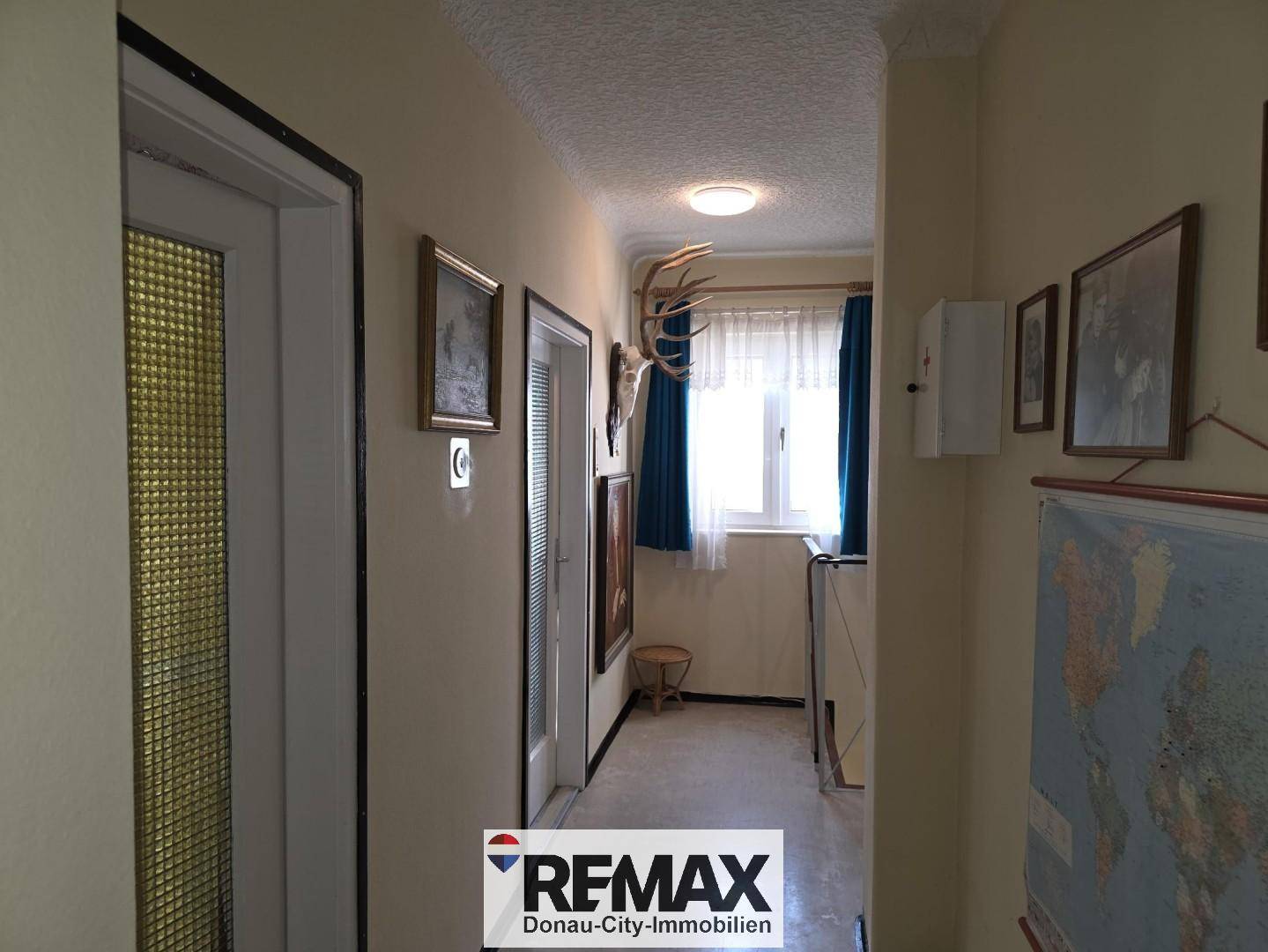 Flur mit Geweihdekoration und Fenster, das Tageslicht hereinlässt.