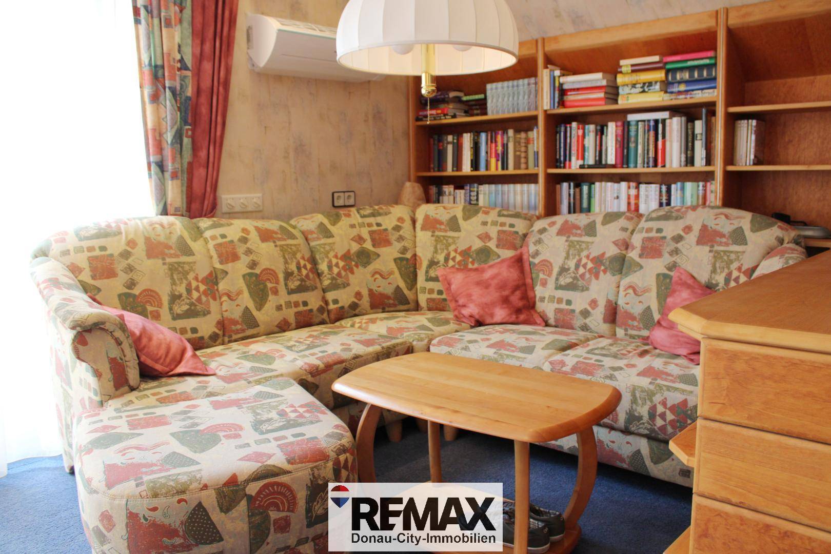 Gemütlicher Schlafbereich mit Ecksofa, Couchtisch und Bücherregalen, ideal zum Entspannen.