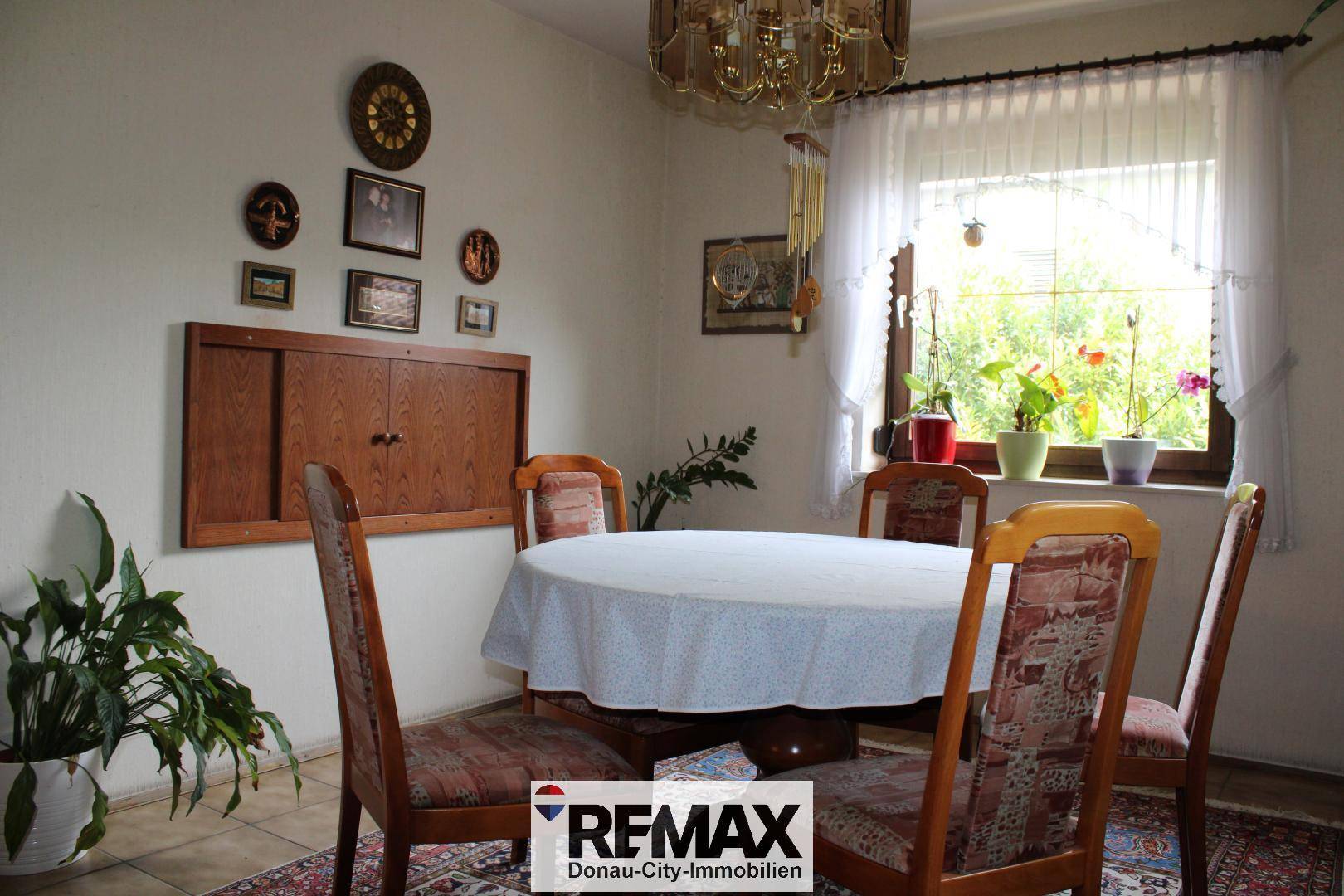 Gemütlicher Essbereich mit rundem Tisch, Stühlen und traditioneller Dekoration an den Wänden.