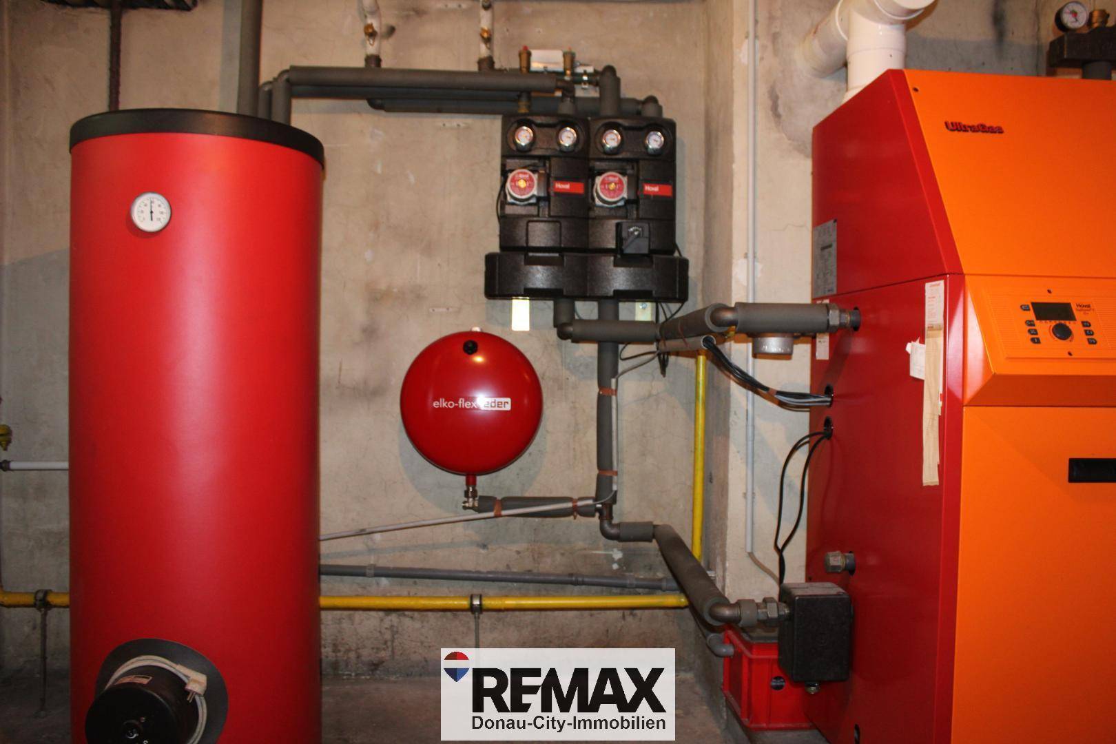 Heizungsraum im Keller mit Warmwasserspeicher und Heizkessel, gut gewartet.