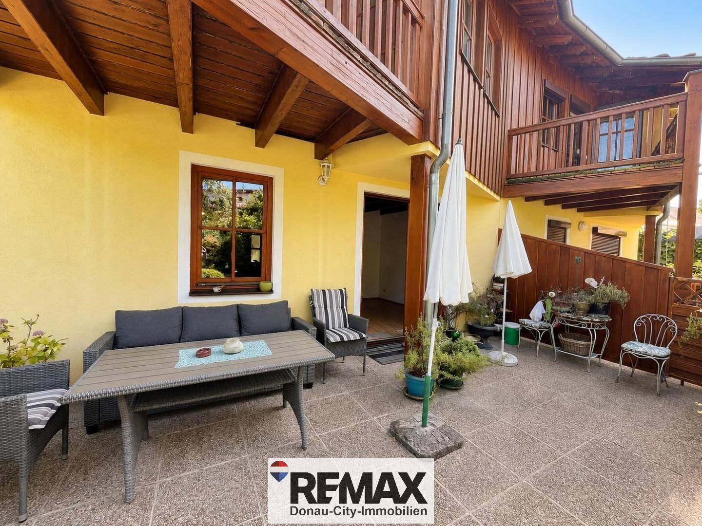 Gemütliche Terrasse mit Gartenmöbeln und Sonnenschirmen, ideal zum Entspannen.