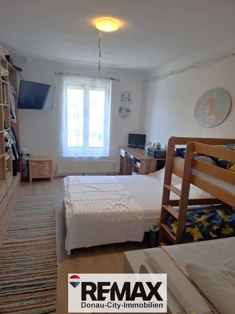 Kinderzimmer mit Etagenbett, Einzelbett und großem Einbauschrank.