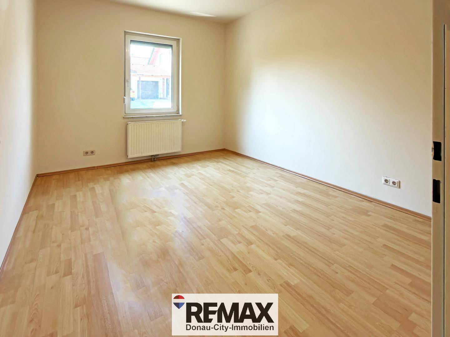Helles Zimmer mit Laminatboden und einem Fenster, ideal als Schlaf- oder Kinderzimmer.