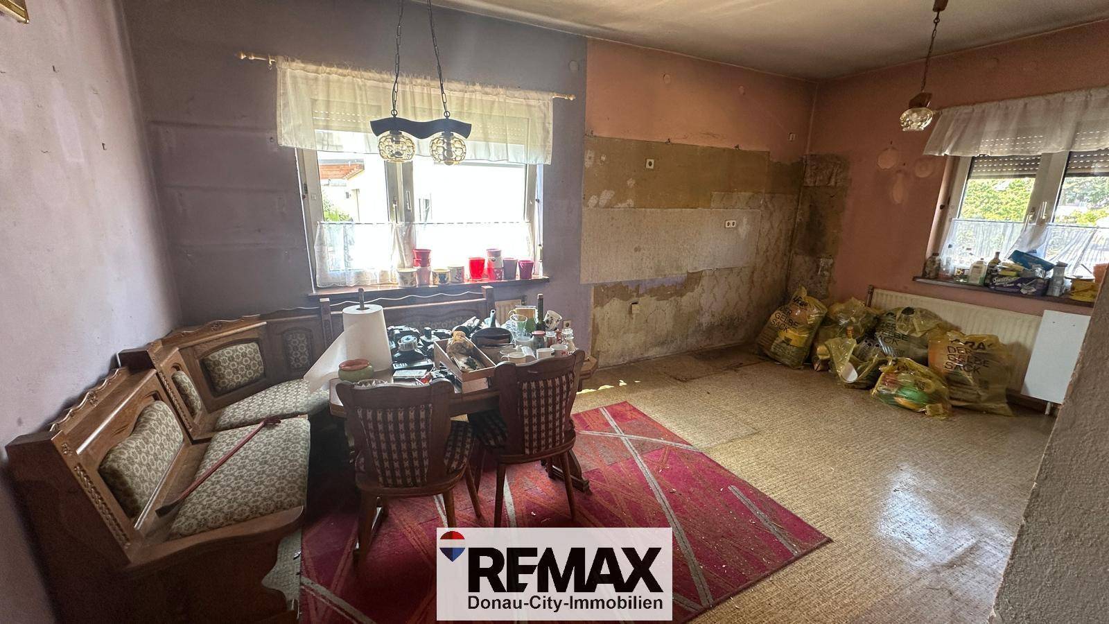 Renovierungsbedürftiger Raum mit Fenster und Heizkörper, bereit für eine Neugestaltung.