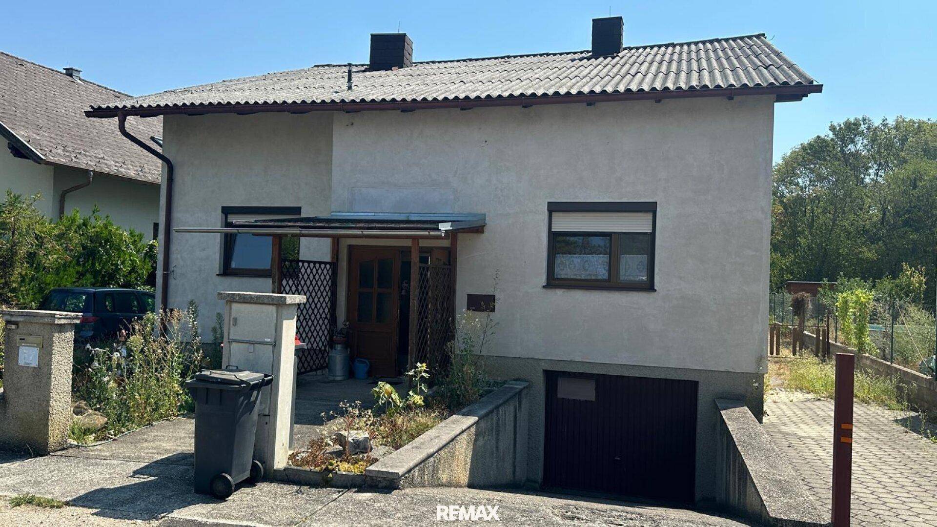 Vorderansicht des Hauses mit Garagenzufahrt, Eingangsbereich und Satteldach.