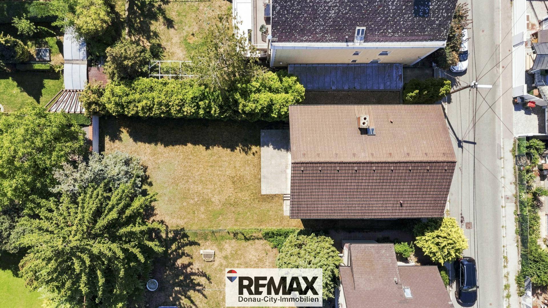 Draufsicht aus der Luft auf das Haus, den Gartenbereich und die angrenzende Straße.