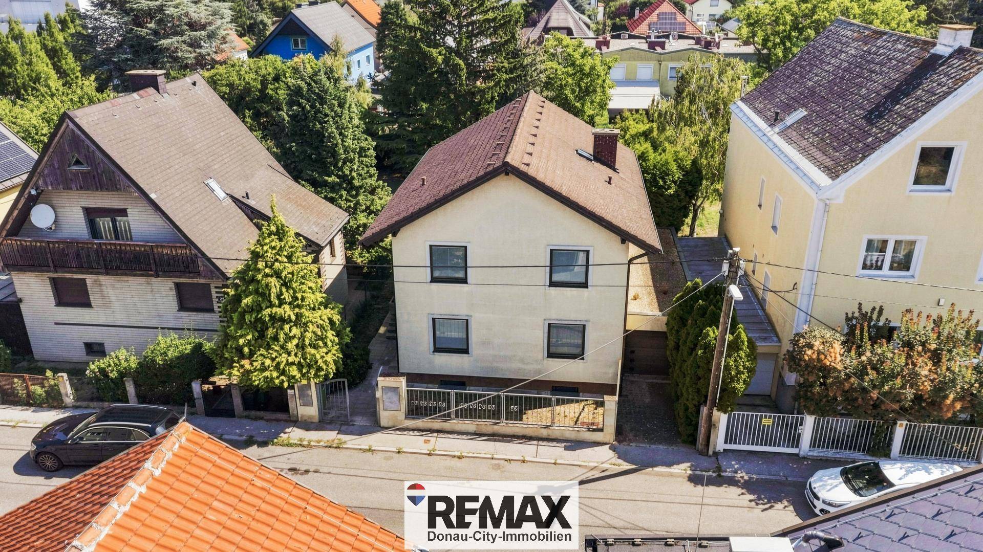 Luftaufnahme der Vorderseite des Hauses mit Straße und angrenzenden Gebäuden in der Umgebung.