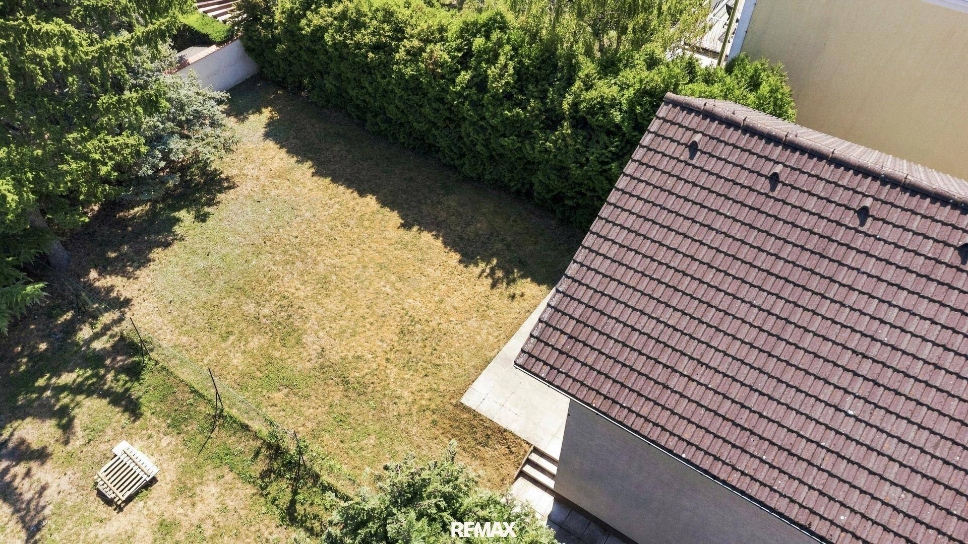 Vogelperspektive des Hauses mit braunem Dach und dem weitläufigen Gartenbereich.