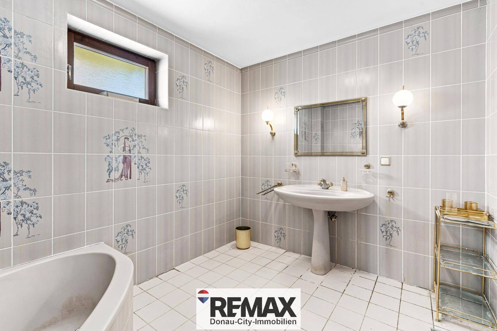 Badezimmer mit Badewanne, Waschbecken und Fenster.