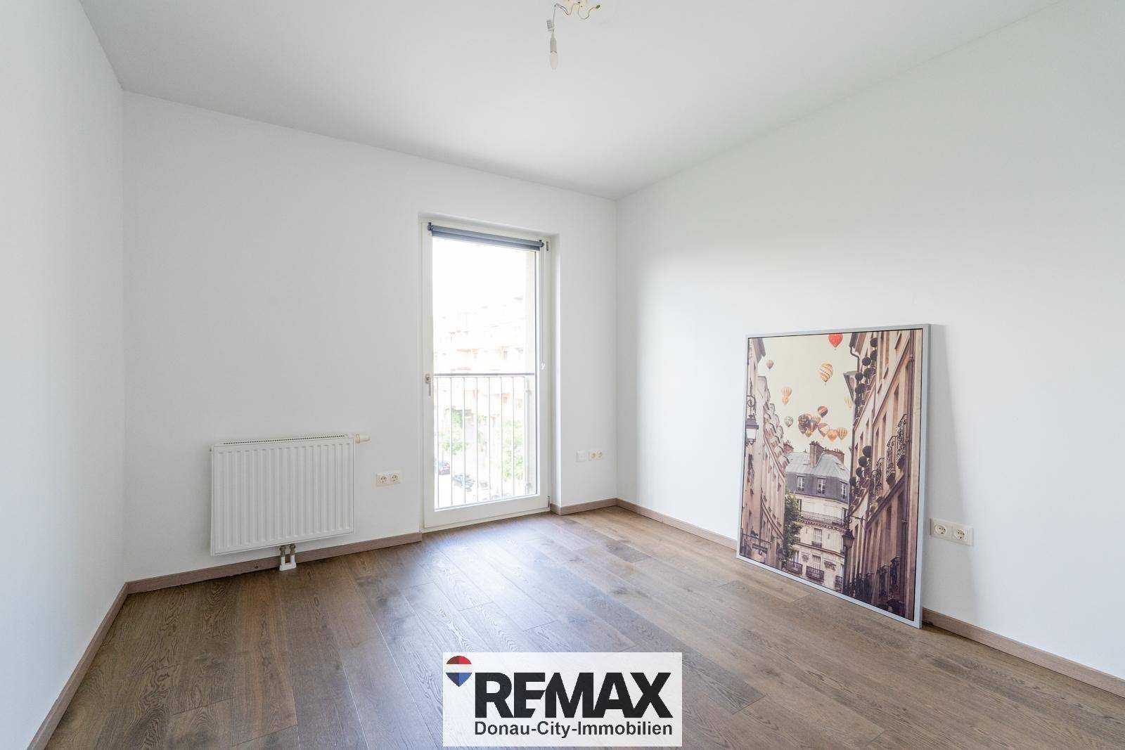 Helles Schlafzimmer mit Holzboden und Zugang zu einem französischen Balkon, bereit zur Gestaltung.
