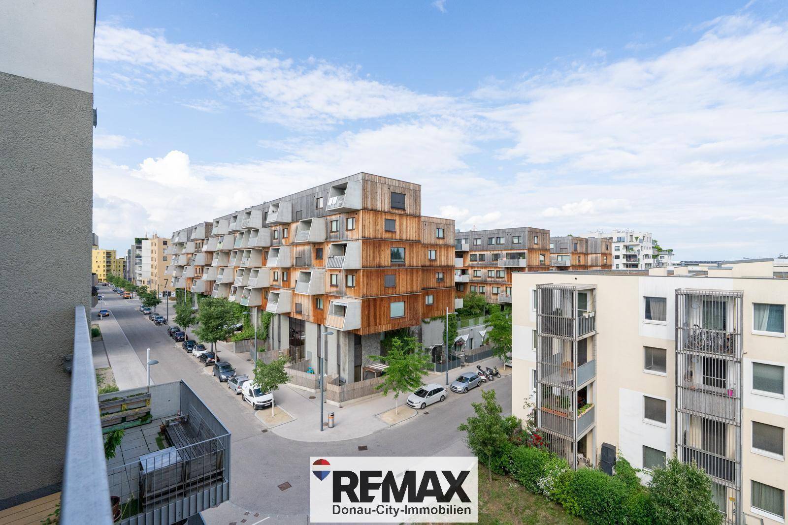Weitblick vom Balkon über die umliegenden modernen Gebäude und die grüne Umgebung.