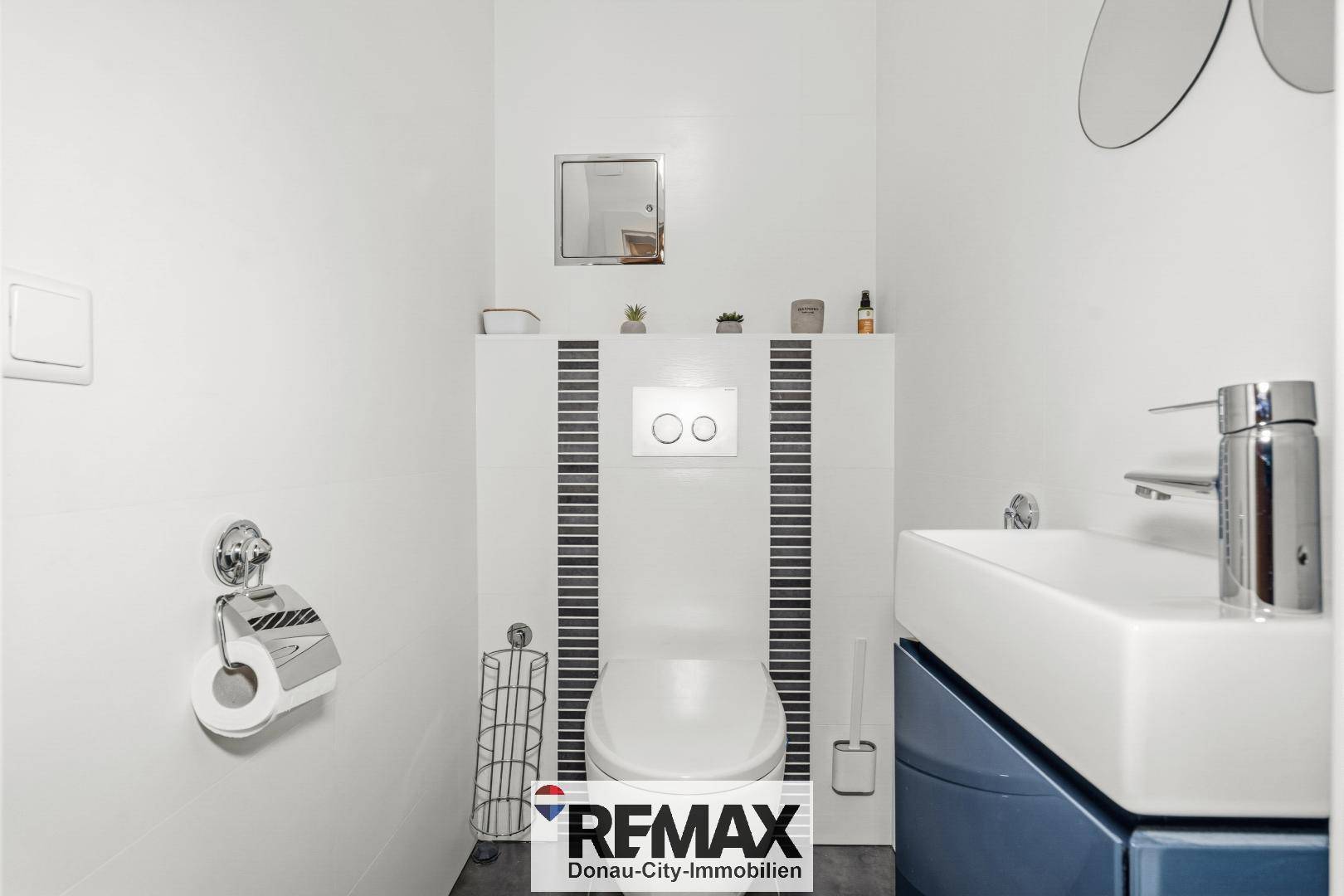 Modernes Gäste-WC mit wandhängendem WC, kleinem Waschbecken und weißen Fliesen.