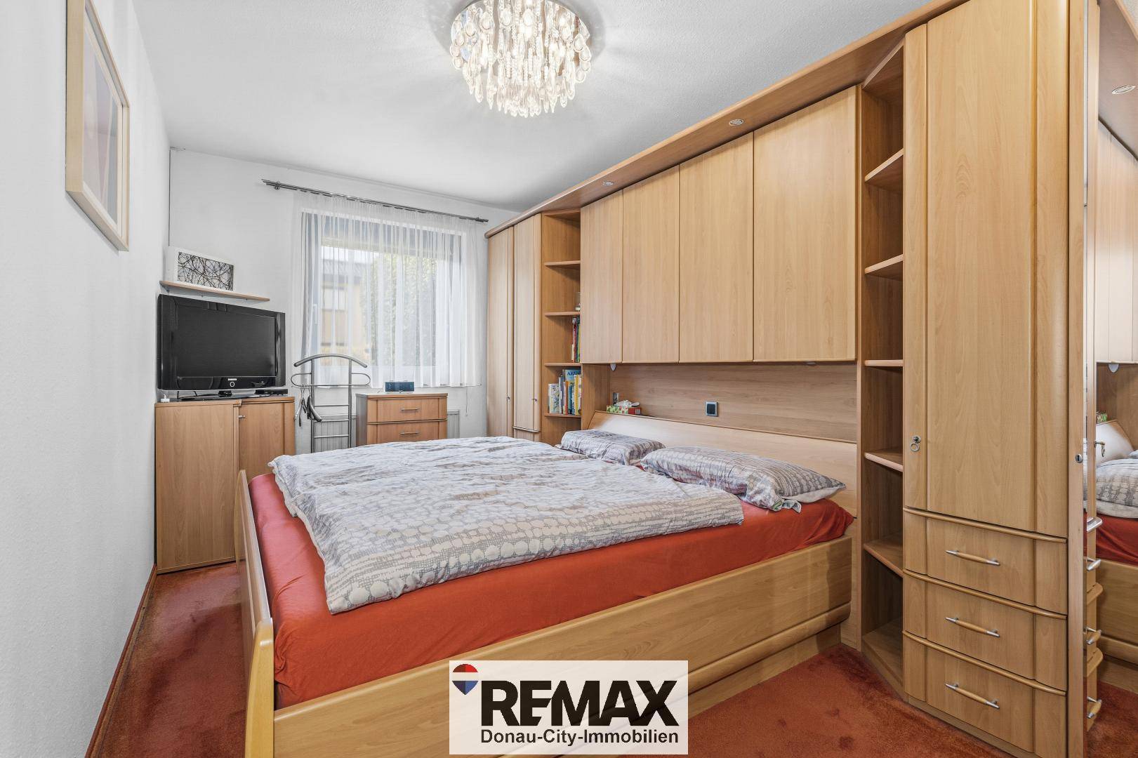 Geräumiges Schlafzimmer mit Doppelbett, Einbauschränken und Teppichboden.