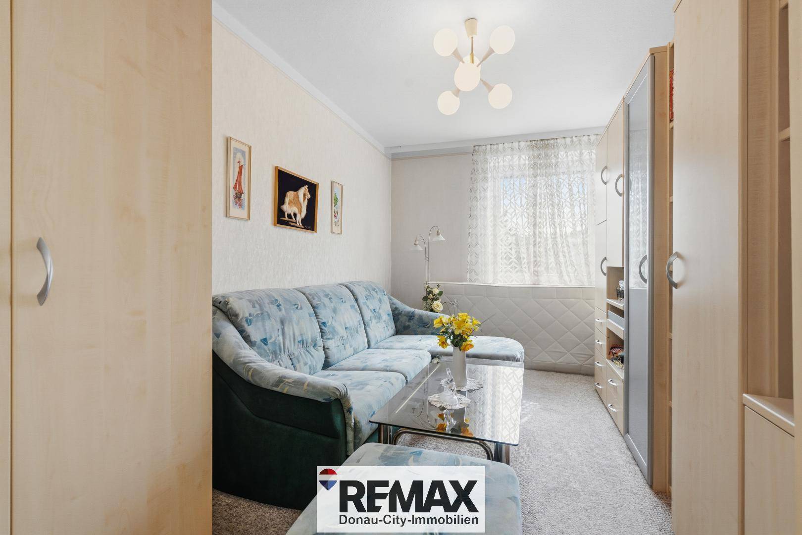 Schlafzimmer oder Gästezimmer mit Teppichboden, einem Sofa und Einbauschränken.