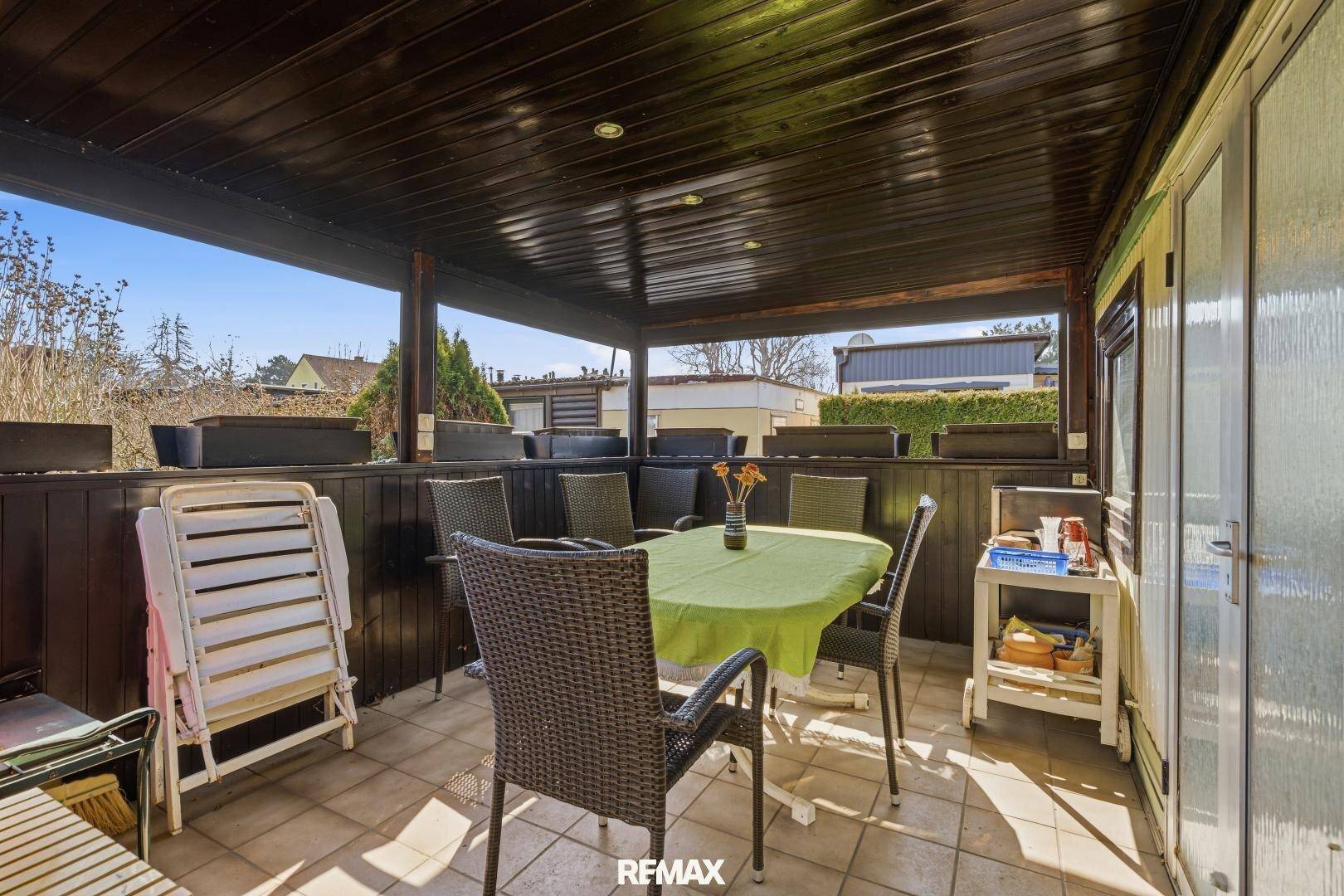 Überdachte Terrasse mit Gartenmöbeln, ideal für entspannte Stunden im Freien.