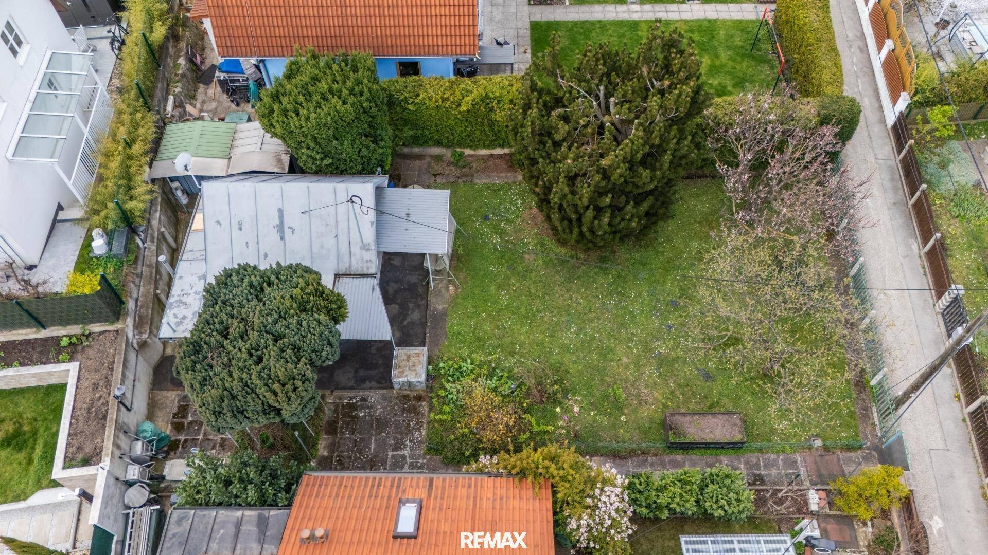 Luftaufnahme des Grundstücks mit dem kleinen Haus, Garten und angrenzenden Gärten.
