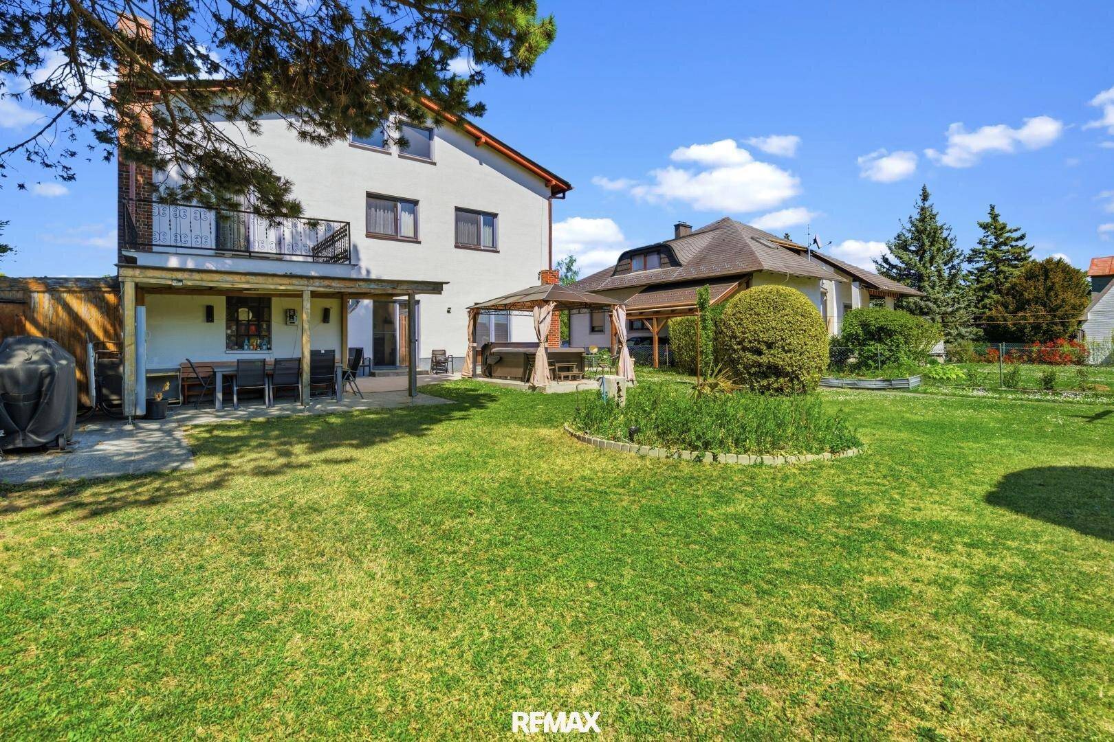 Weitläufiger Garten mit Rasen, verschiedenen Pflanzen und einem Whirlpool-Bereich.