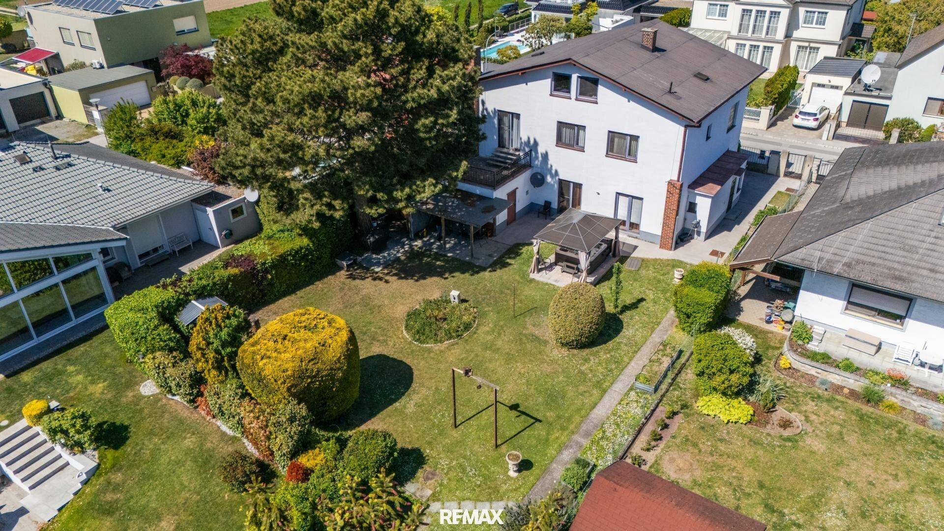 Rückansicht des Hauses mit großem Garten, Terrasse und einem Pavillon für entspannte Stunden.