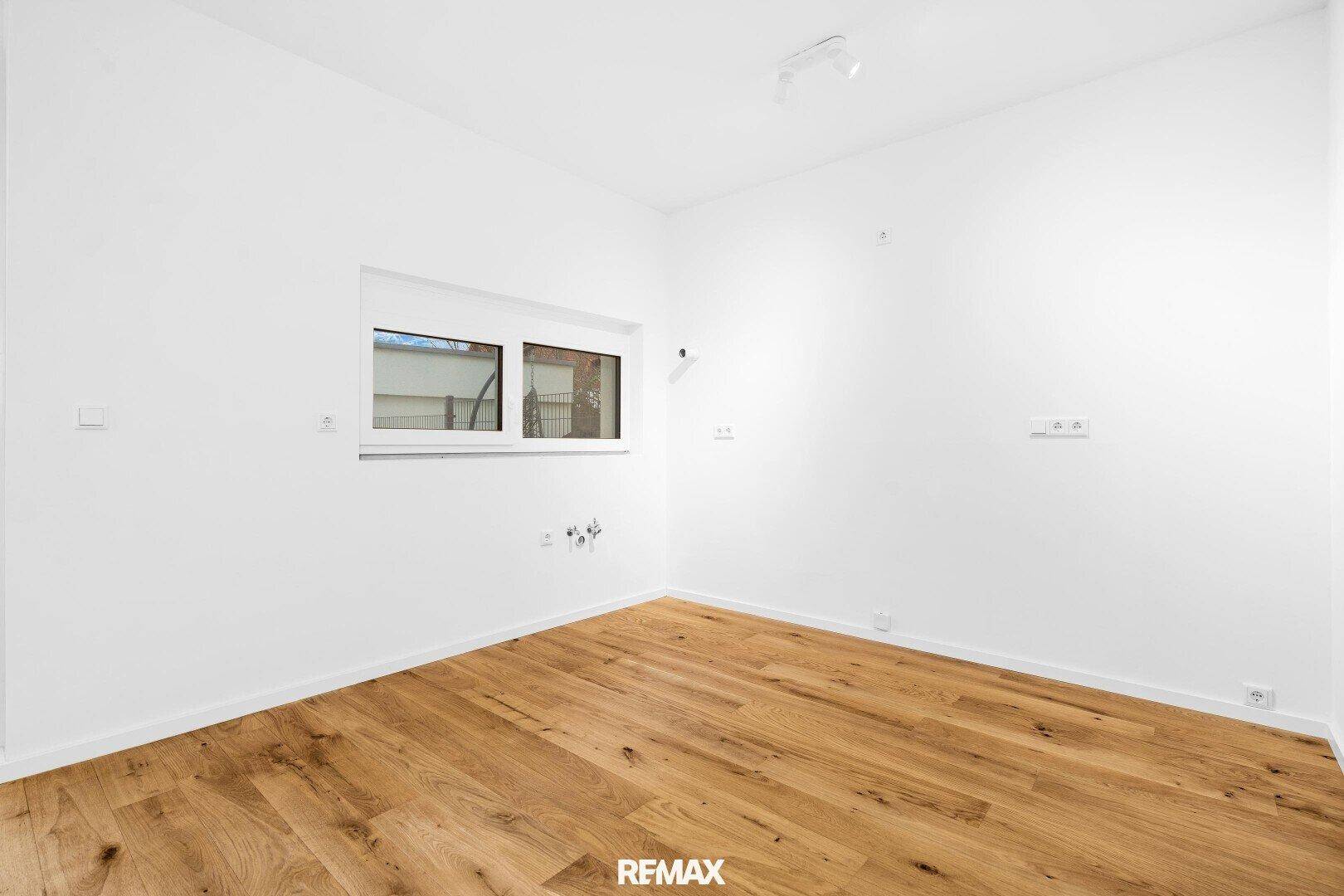 Leerer Raum mit Holzboden und einem Fenster, bereit zur individuellen Gestaltung und Nutzung.