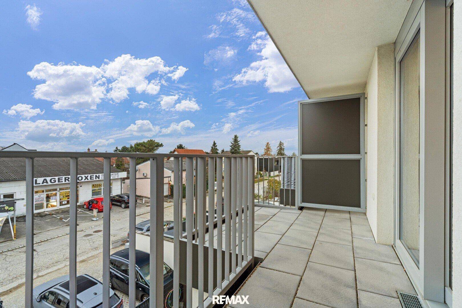 Geräumiger Balkon mit Fliesenboden und Blick auf die Umgebung, ideal zum Entspannen im Freien.