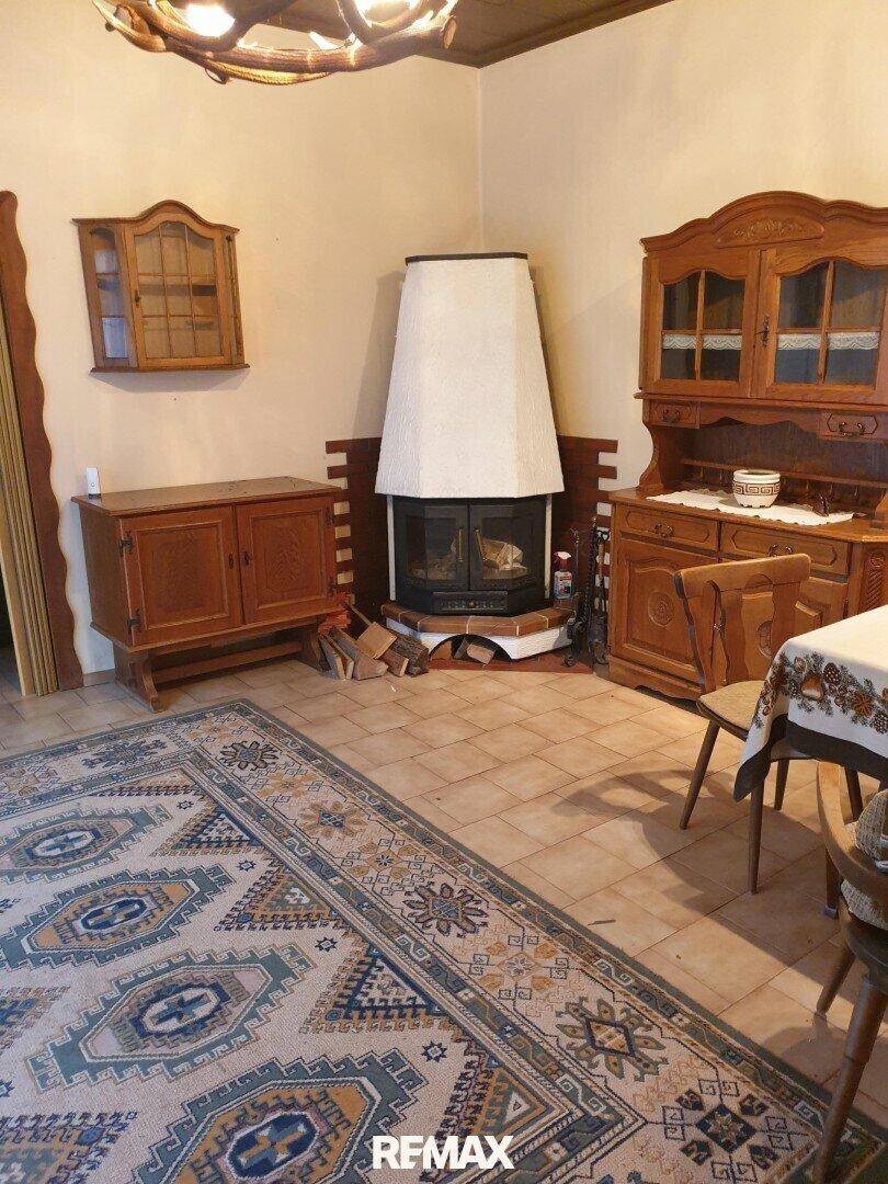 Gemütliches Wohnzimmer im traditionellen Stil mit Kamin, Holzmöbeln und Fliesenboden.