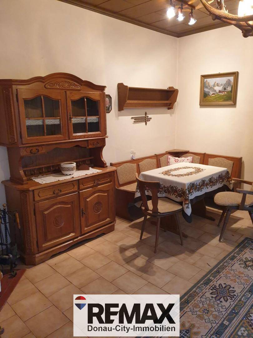 Traditioneller Essbereich mit Eckbank, rustikalen Holzmöbeln und Fliesenboden.