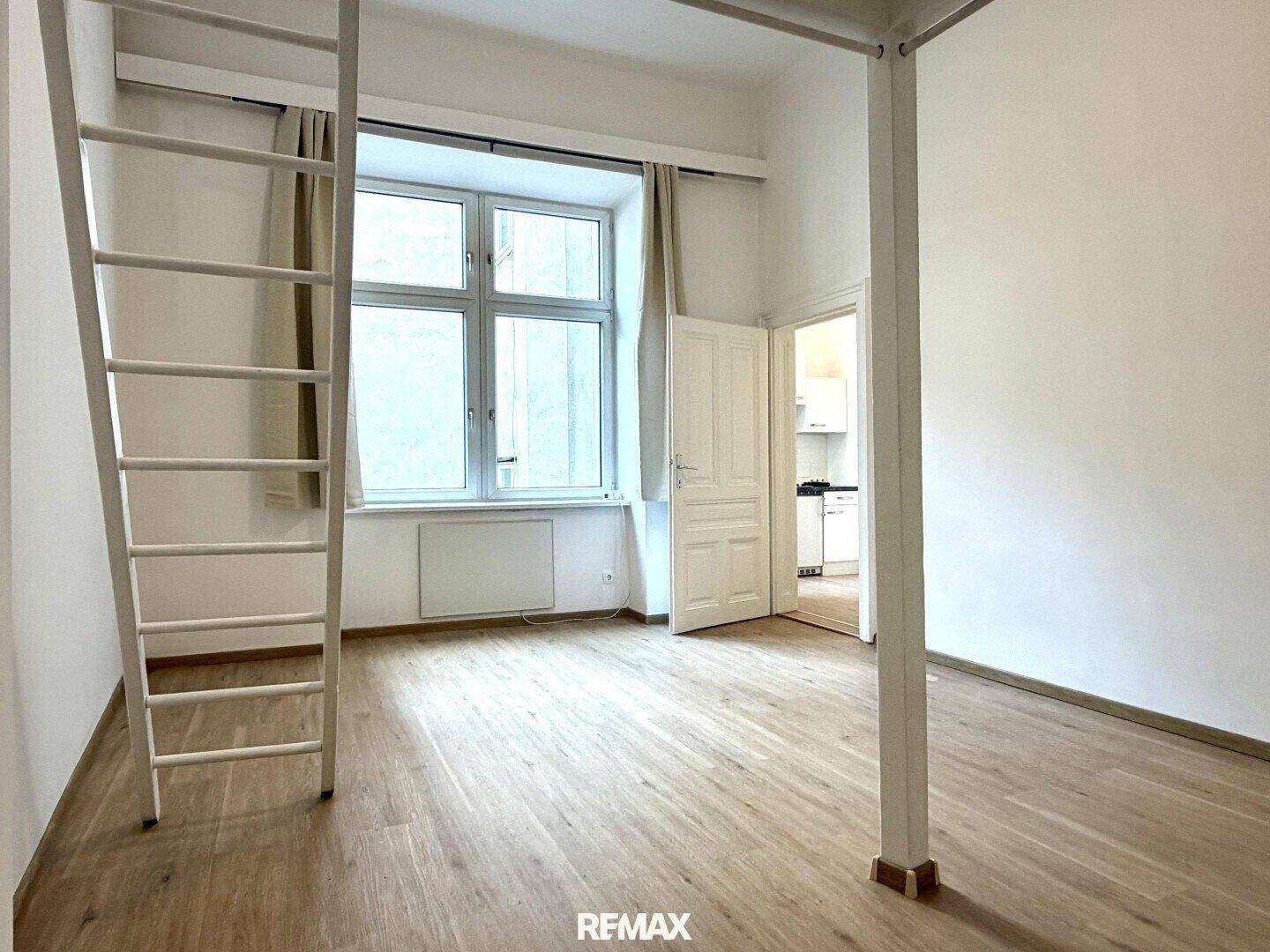 Geräumiges Zimmer mit Fenster und Zugang zur Küche, ausgestattet mit einem Hochbett.