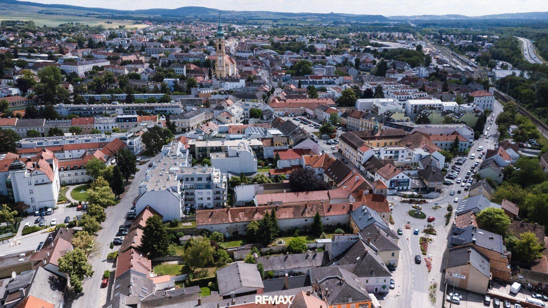 Weitläufige Luftaufnahme einer Stadt mit umliegender Landschaft und vielen Gebäuden.