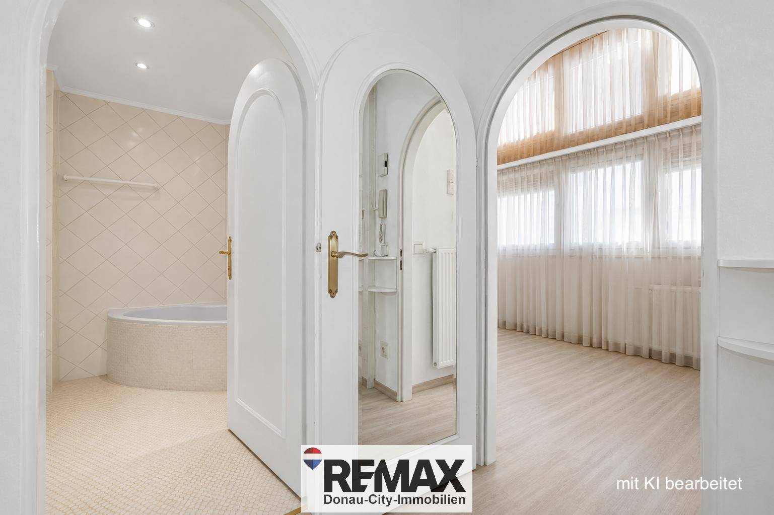Blick durch einen Torbogen in ein Badezimmer mit Badewanne und angrenzendem Raum.