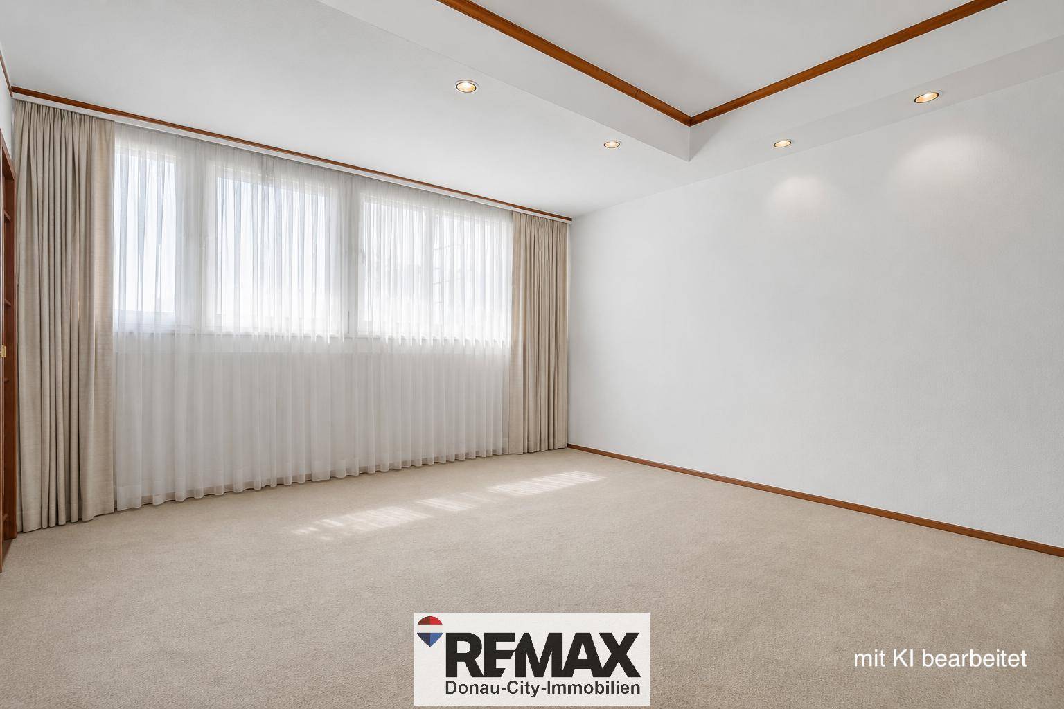 Heller Raum mit Teppichboden und breiter Fensterfront mit Vorhängen für Privatsphäre.