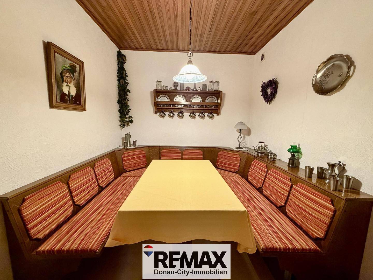 Traditioneller Essbereich mit Eckbank, Holztisch und Holzdeckenverkleidung.