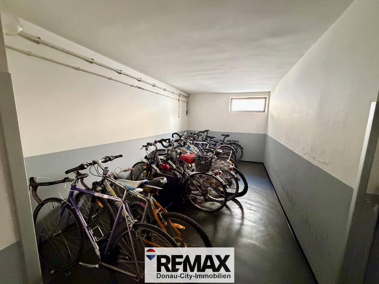 Fahrradraum im Untergeschoss mit zahlreichen Fahrrädern und kleinem Fenster.