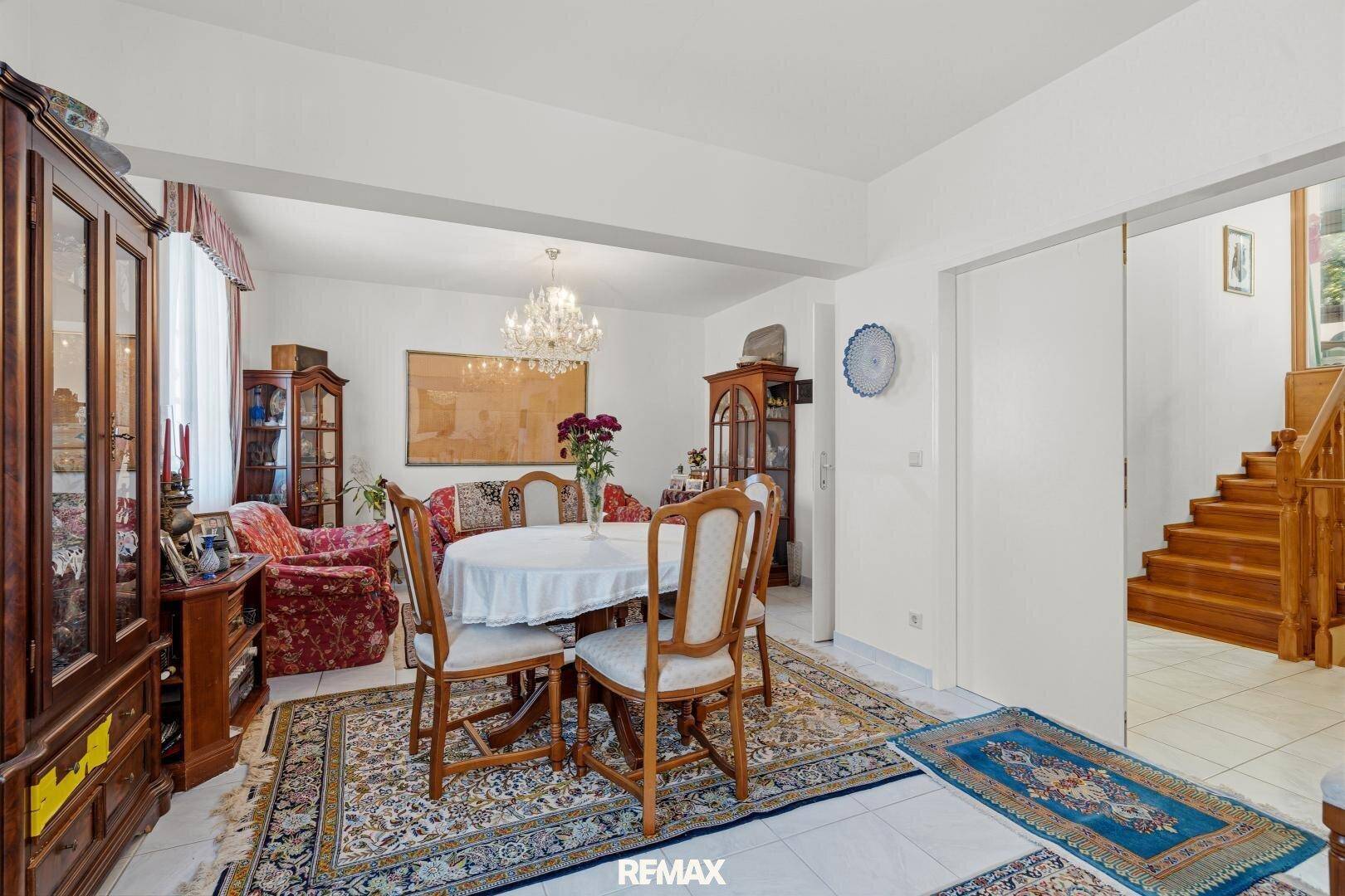 Klassischer Essbereich mit großem Holztisch, traditionellen Möbeln und Zugang zum Wohnzimmer und Treppenhaus.
