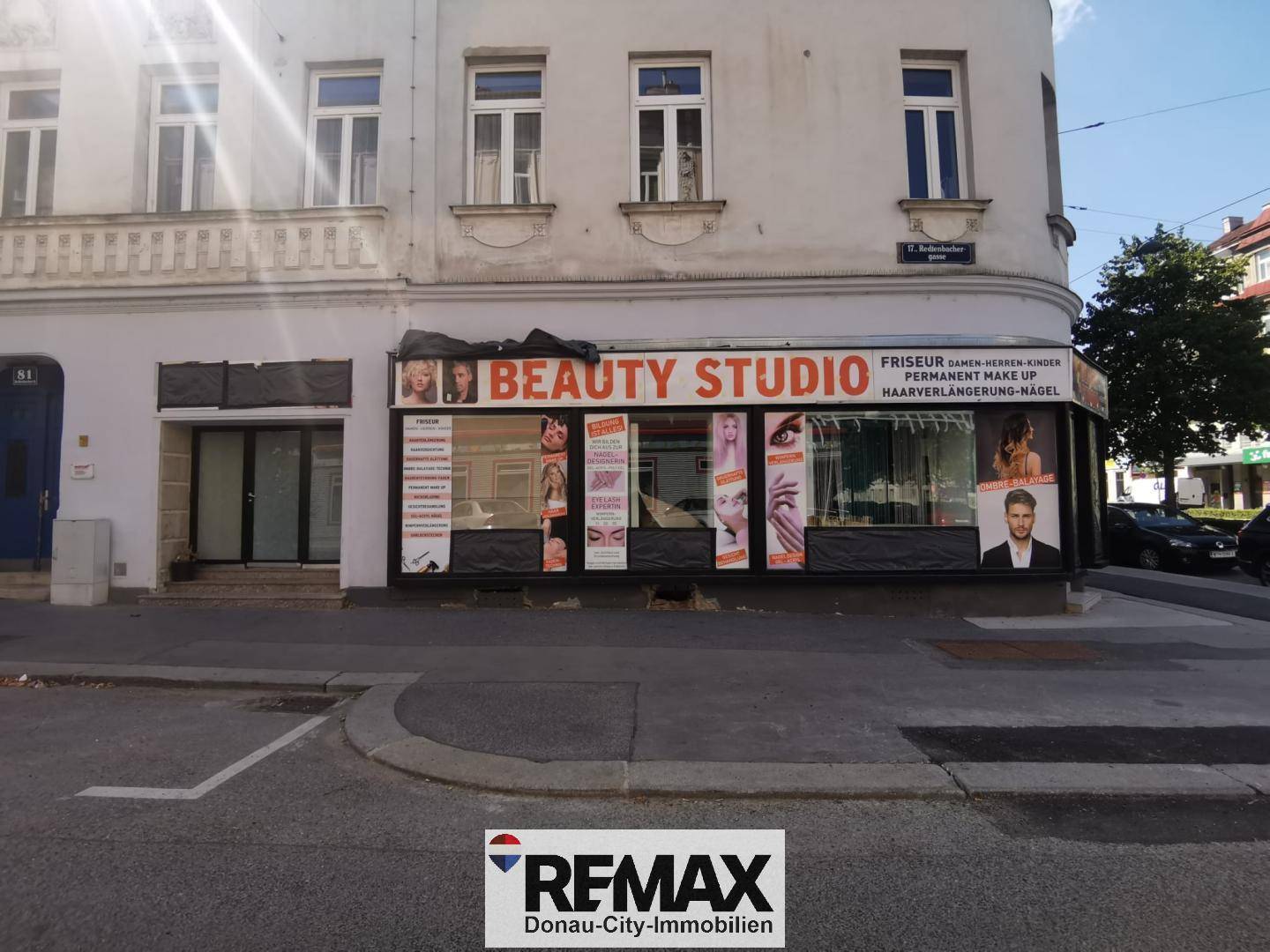 Außenansicht eines Eckgebäudes mit einem "Beauty Studio" im Erdgeschoss und großen Schaufenstern.
