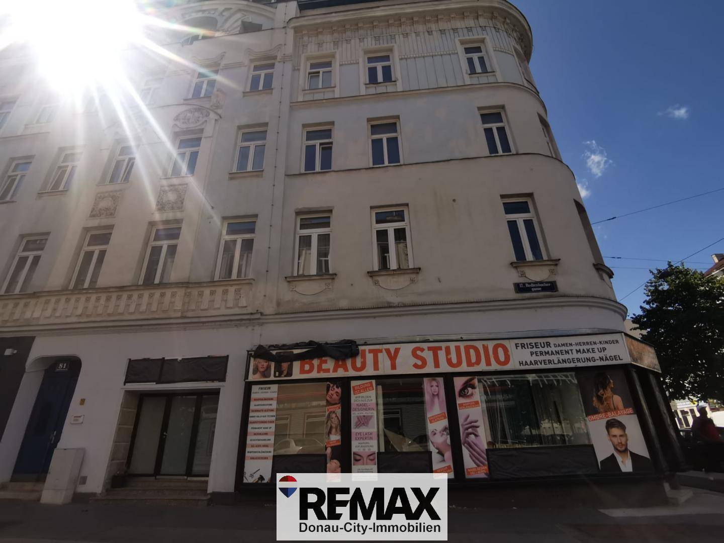 Historisches Gebäude mit einem "Beauty Studio" im Erdgeschoss unter strahlendem Sonnenschein.