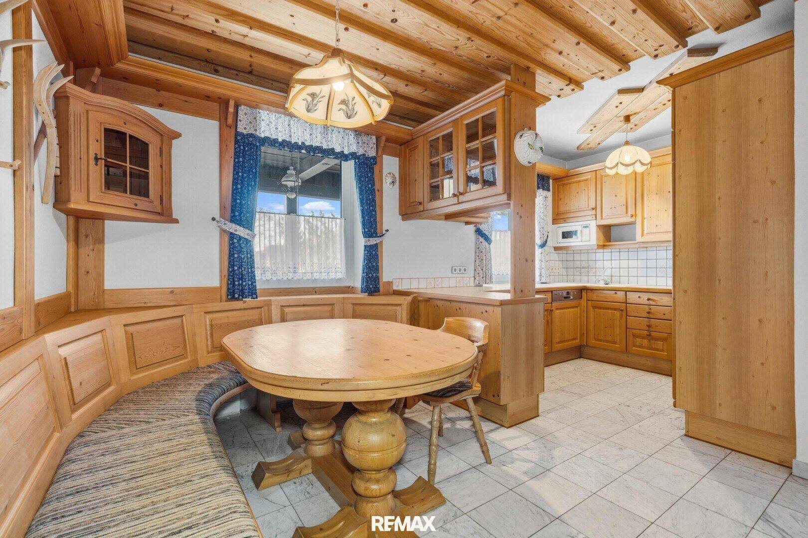 Geräumige traditionelle Holzküche mit Essbereich, Einbauschränken und Fenster.