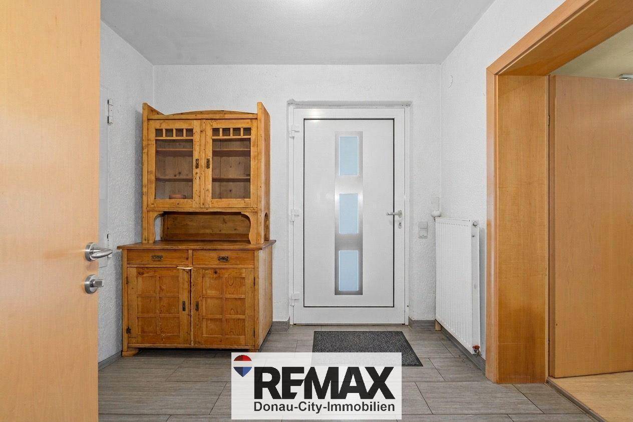 Eingangsbereich mit Holzdielenboden und traditionellem Holzschrank.