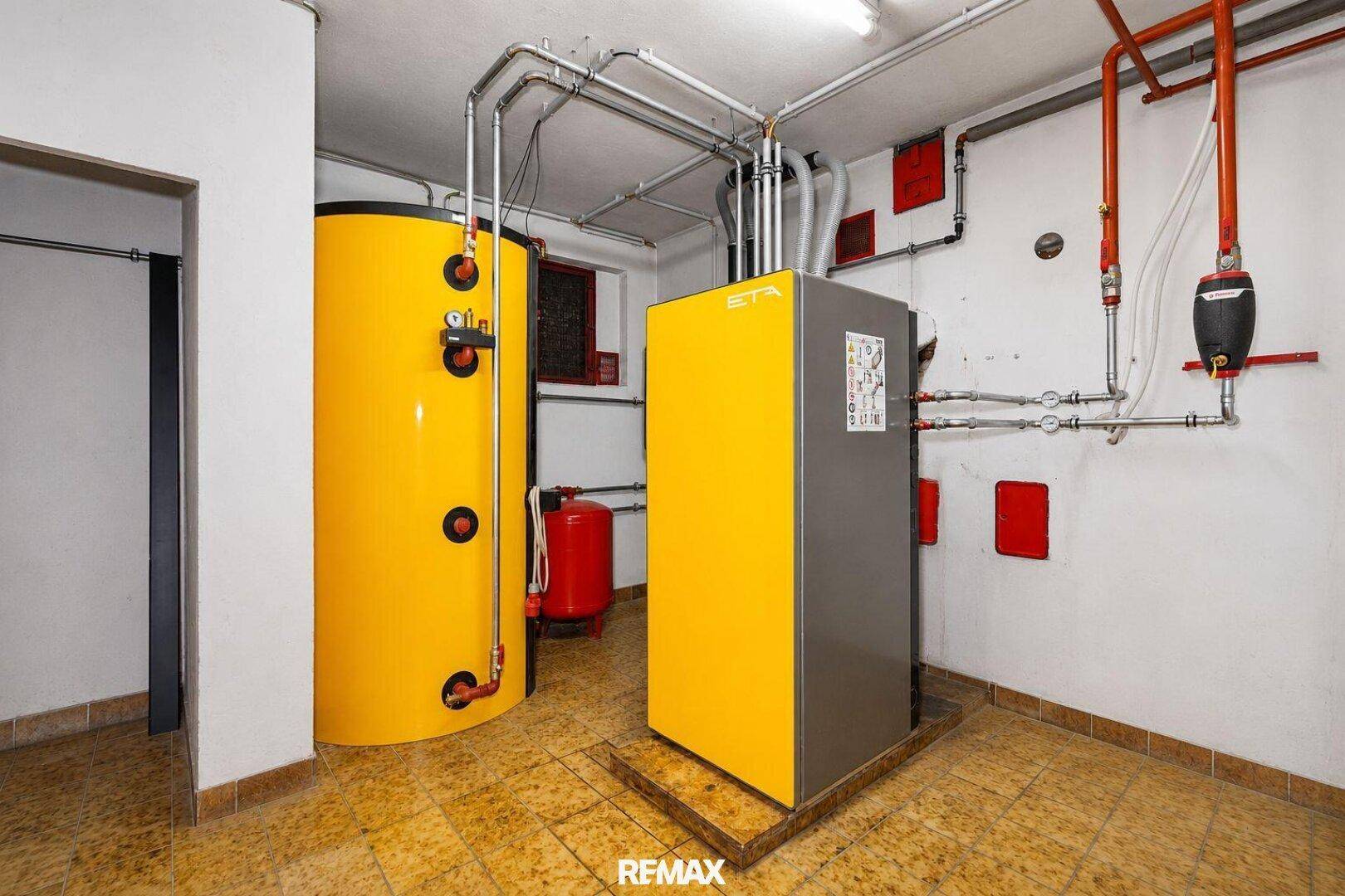 Heizungsraum mit großem Warmwasserspeicher und moderner Heizungsanlage.