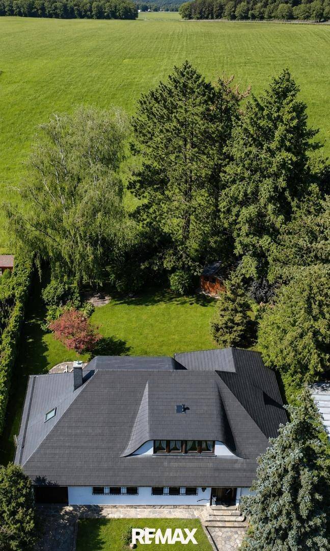 Luftaufnahme des Hauses mit markantem Dach und großem, grünen Grundstück in ländlicher Umgebung.