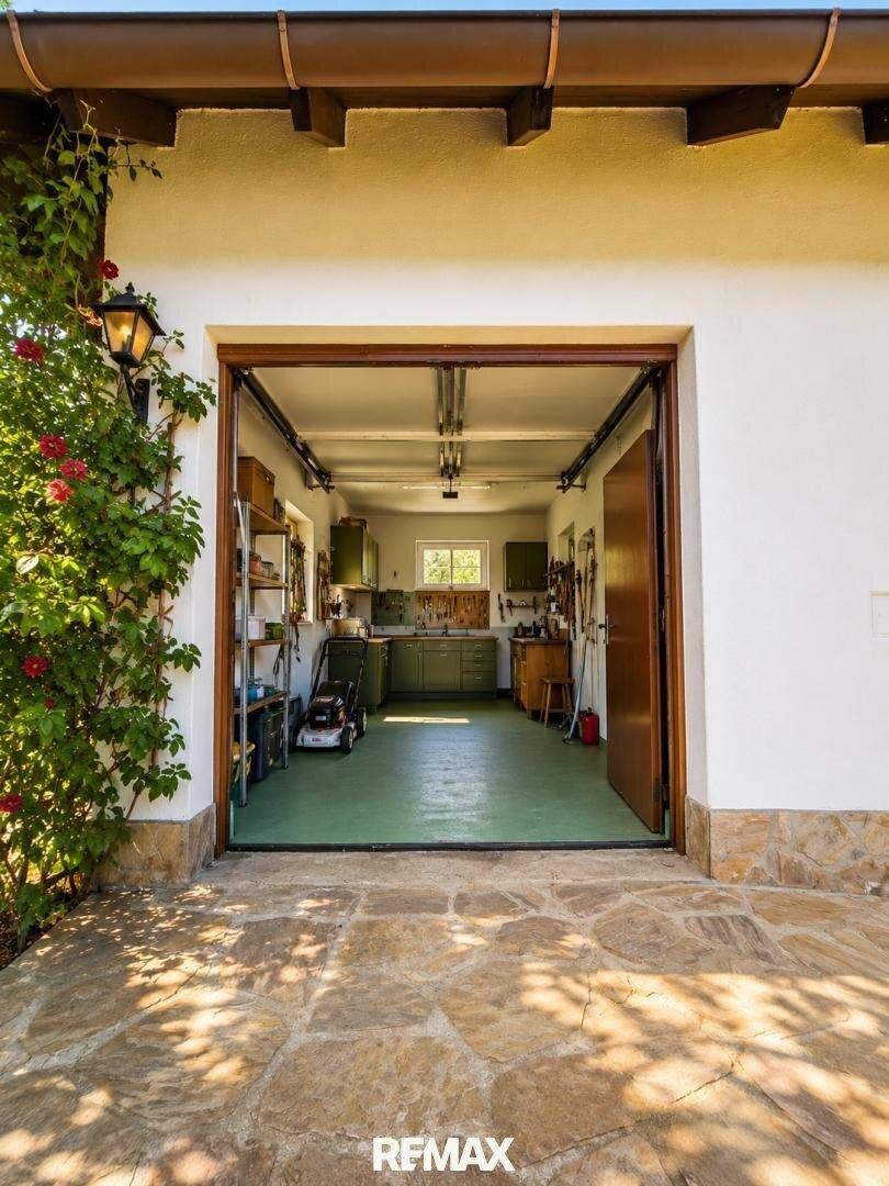 Geräumige Garage mit Werkstattbereich, Stauraum und direktem Zugang zum Außenbereich.